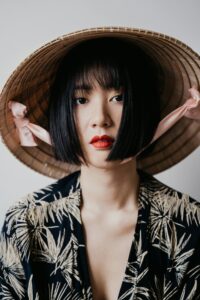 A Woman Wearing a Black Printed Shirt and a Rice Hat