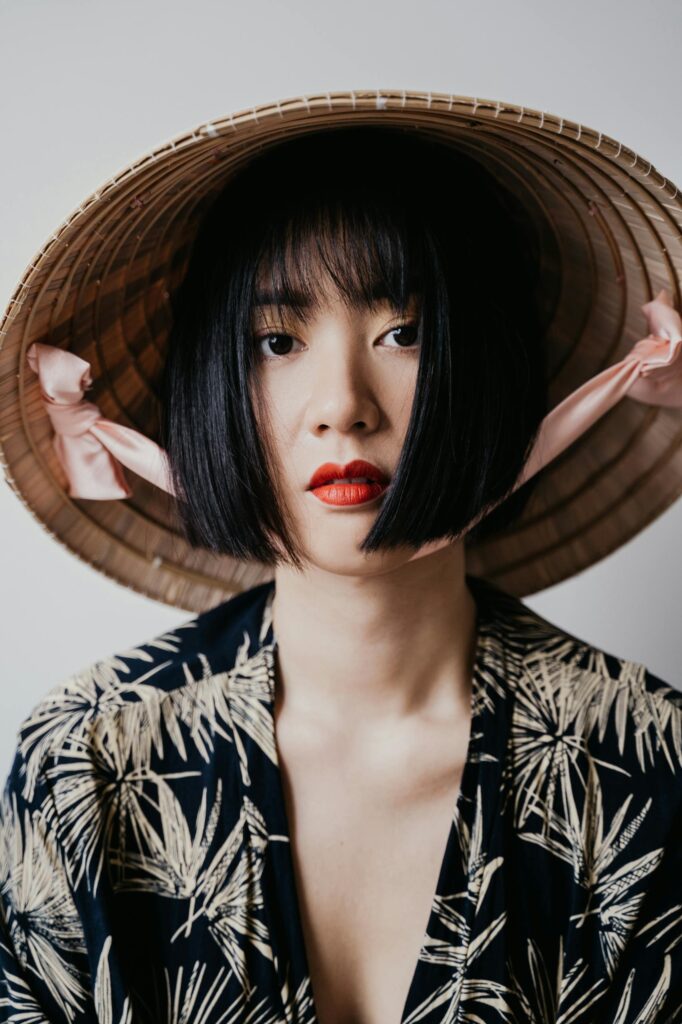 A Woman Wearing a Black Printed Shirt and a Rice Hat